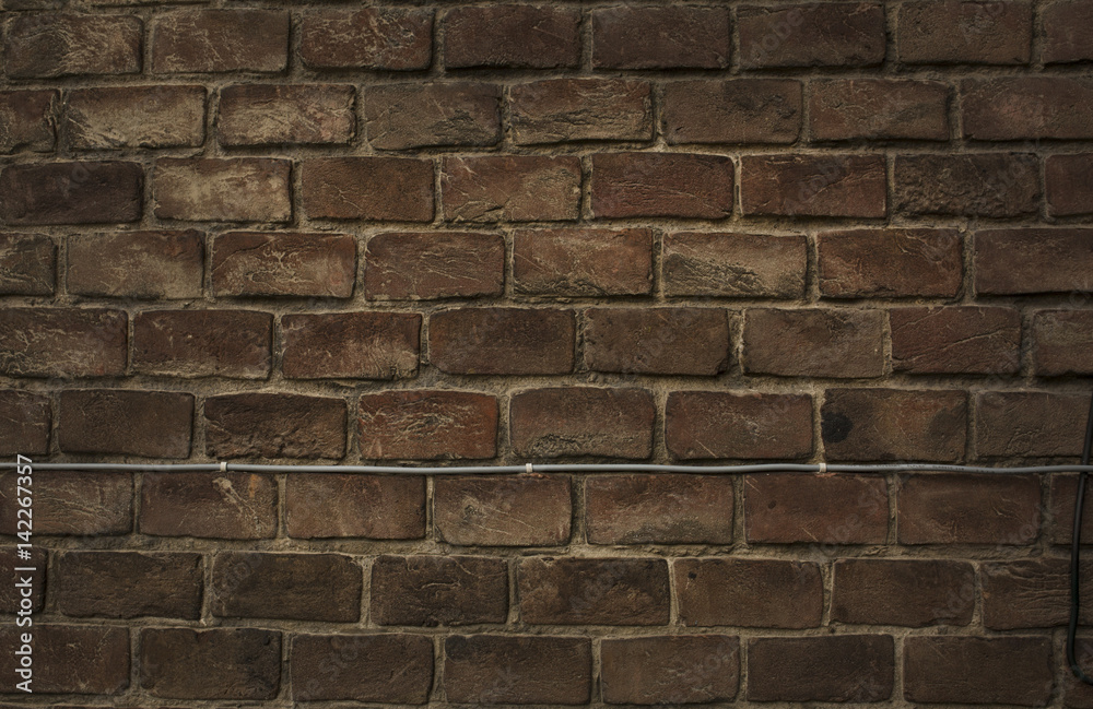 Fototapeta premium Background of red brick wall with wire
