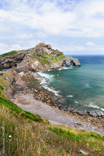 View from the coast on the rock in the ocean with a chapel Doniene Gaztelugatxeko