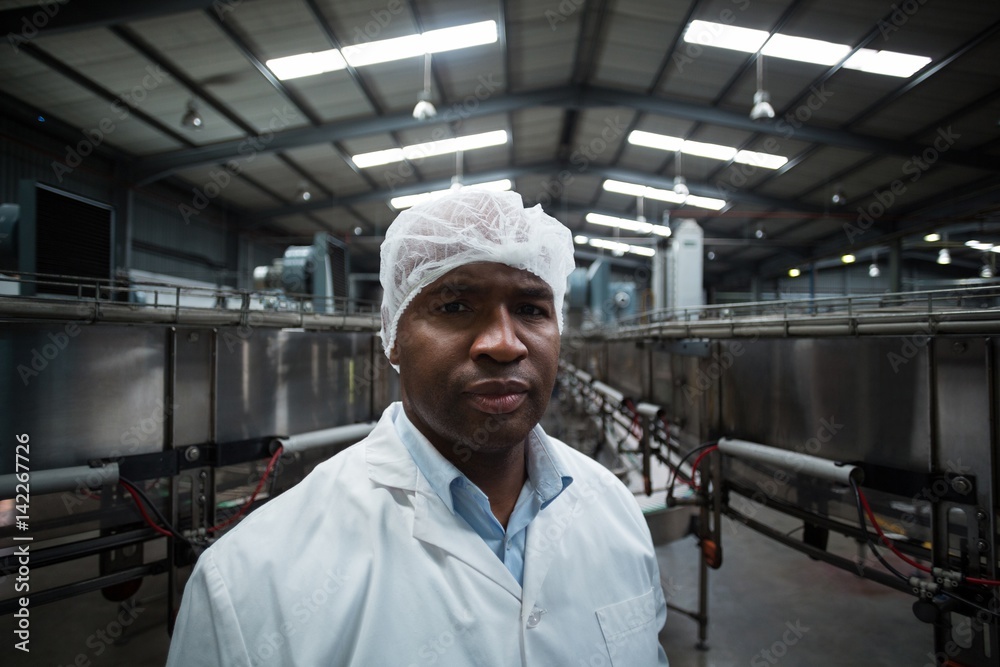 Factory engineer standing in bottle factory Factory engineer standing in bottle factory