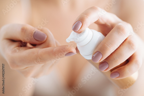 woman hands applying moisturizing cream to her skin photo