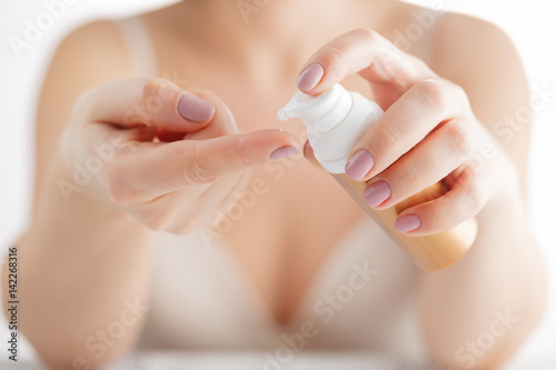beauty girl applying some white lotion on forefinger of her hand