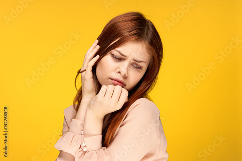 puzzled woman touches her face with her hands
