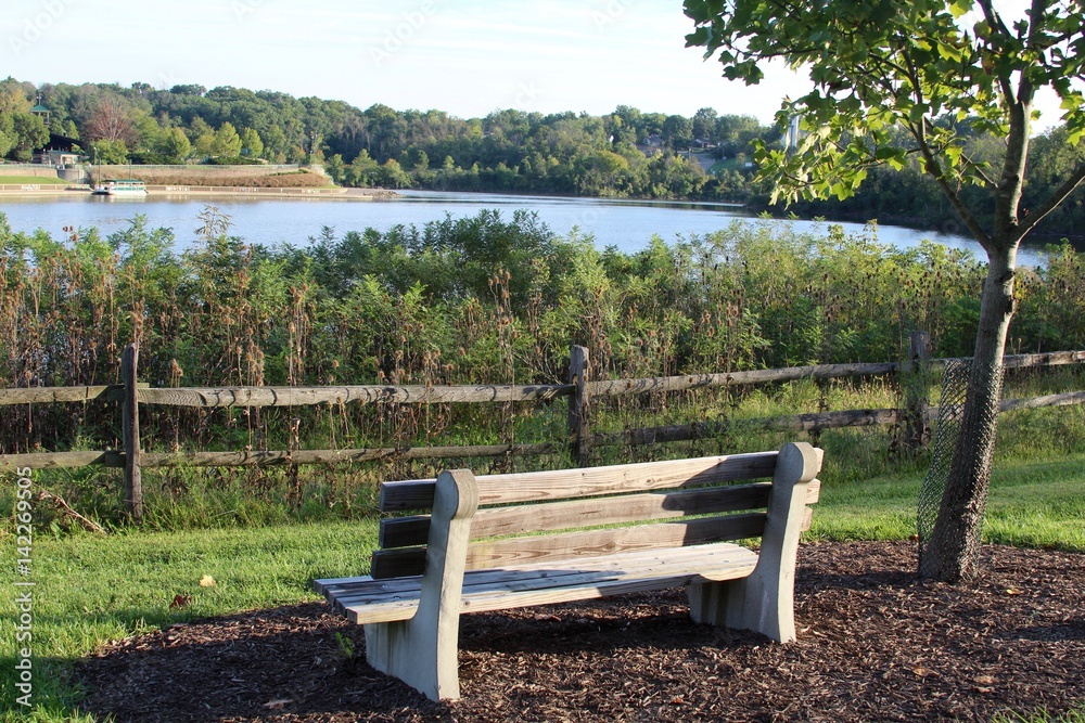 The empty park bench at the lake in the early morning.