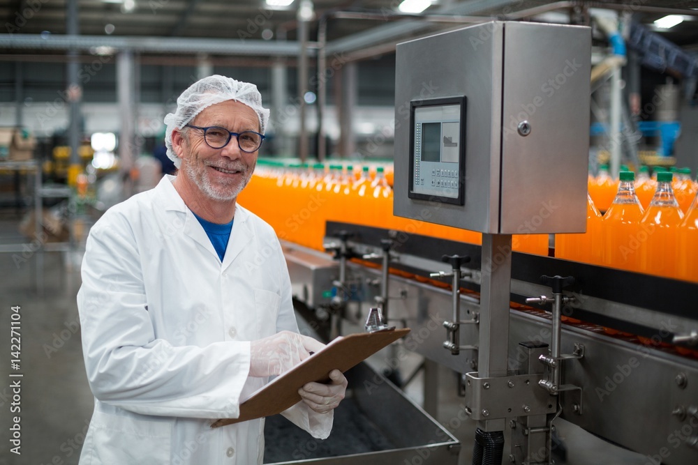 Factory engineer maintaining record on clipboard Factory engineer maintaining record on clipboard