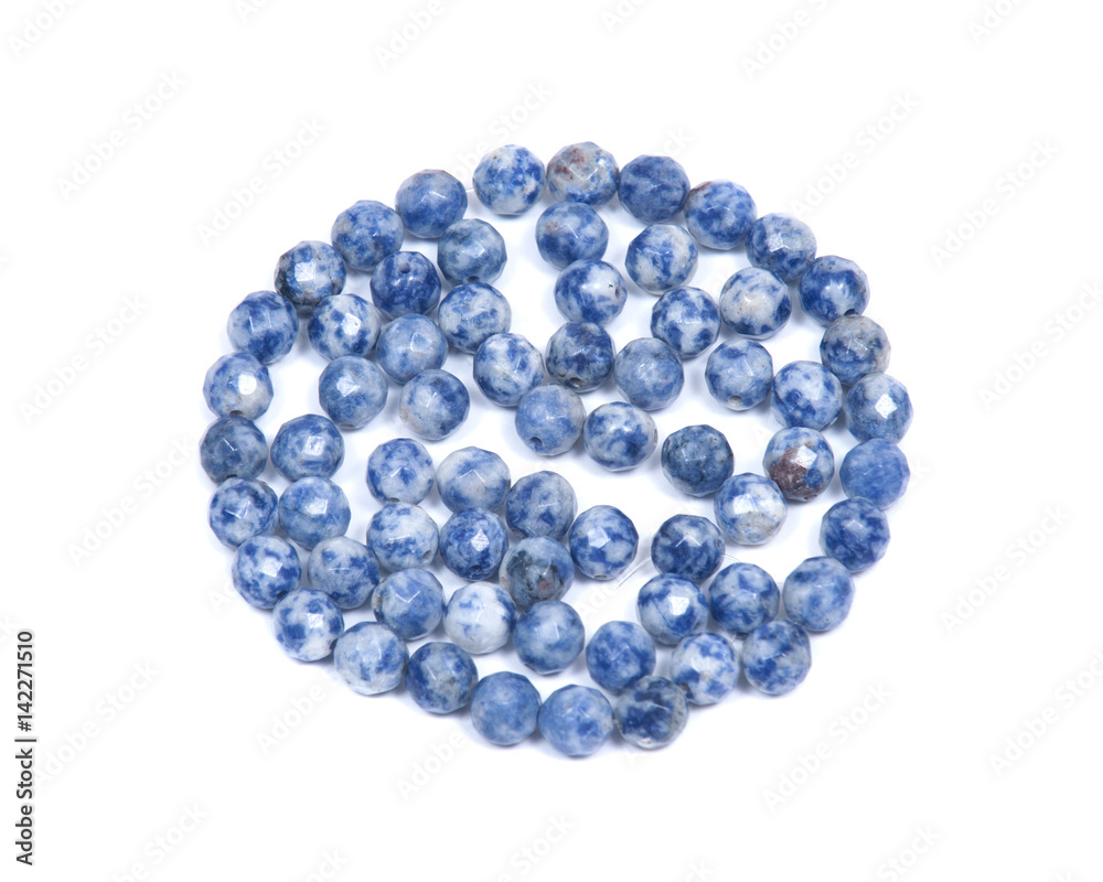 Faceted round beads of blue and white sodalite from Africa isolated on white background Faceted round beads of blue and white sodalite from Africa isolated on white background