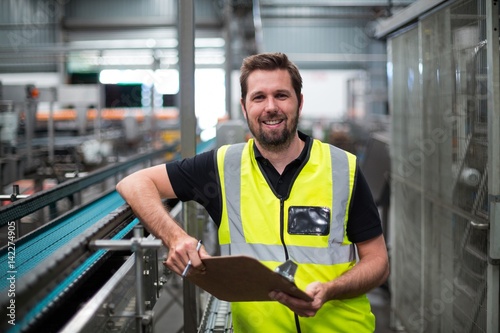 Fotografie Portrait of factory worker standing with clipboard