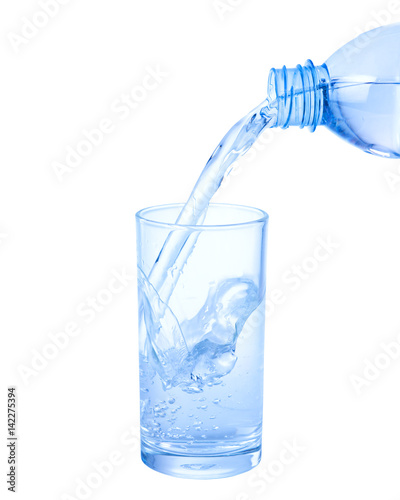 Pouring water from bottle into glass isolated on white background.