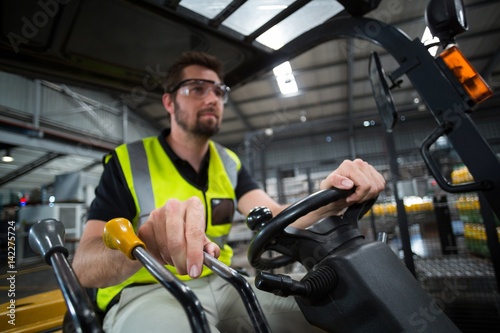 Factory worker driving forklift