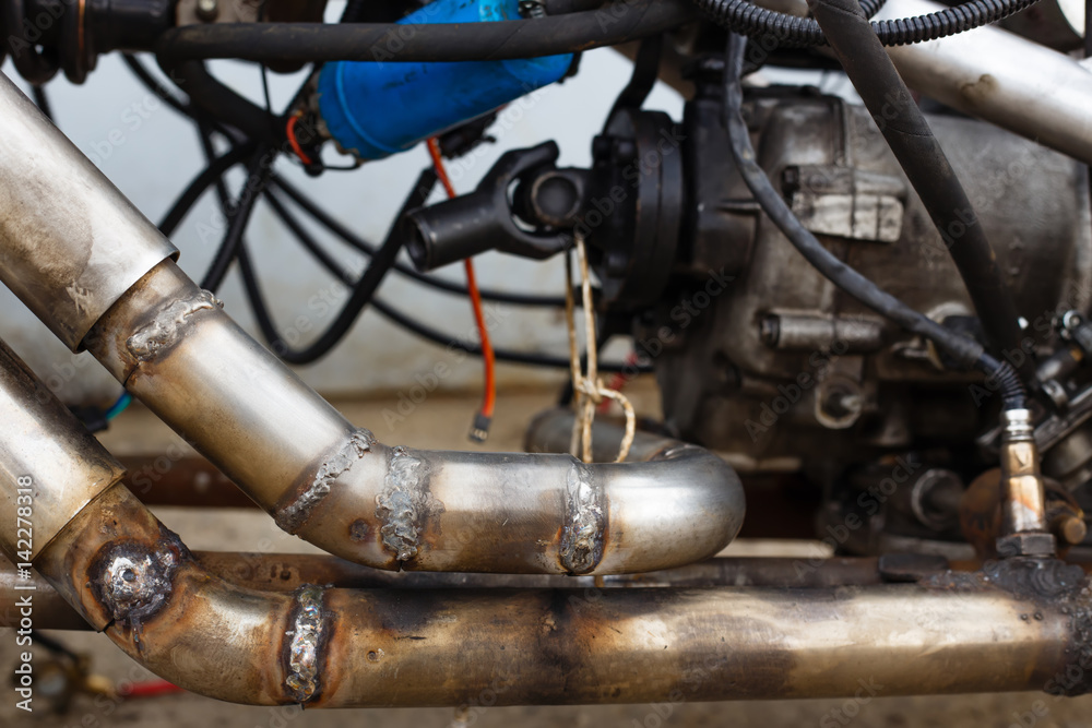 Welded seams on steel exhaust pipe in motorcycle