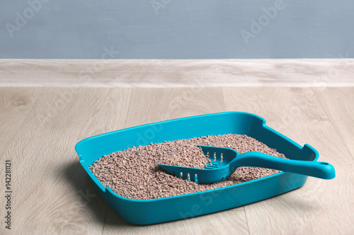 Fototapeta Naklejka Na Ścianę i Meble -  Plastic litter box with filler and scoop on floor