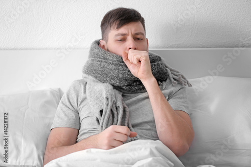 Young ill man in bed at home