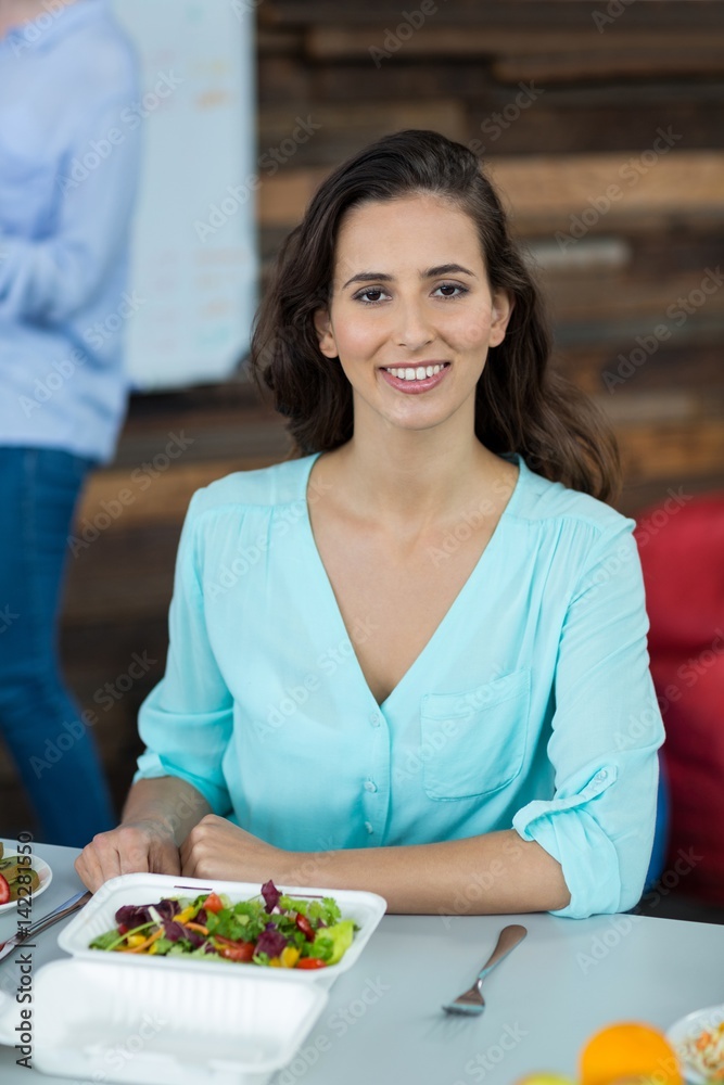 Smiling business executive having meal in office Smiling business executive having meal in office