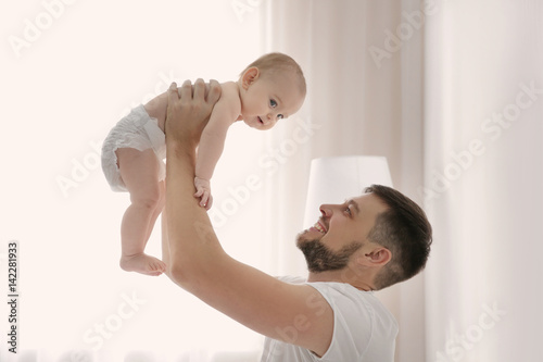 Father holding baby daughte...