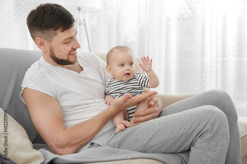 Father sitting with cute ba...