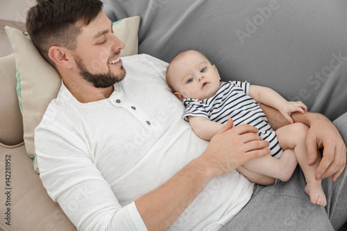 Father lying with cute baby...