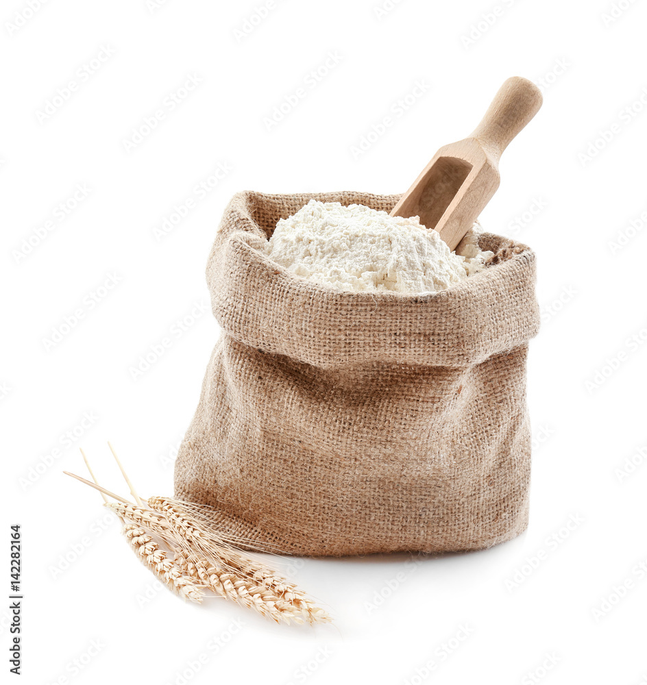 Bag with flour and wooden scoop on white background Photos | Adobe Stock