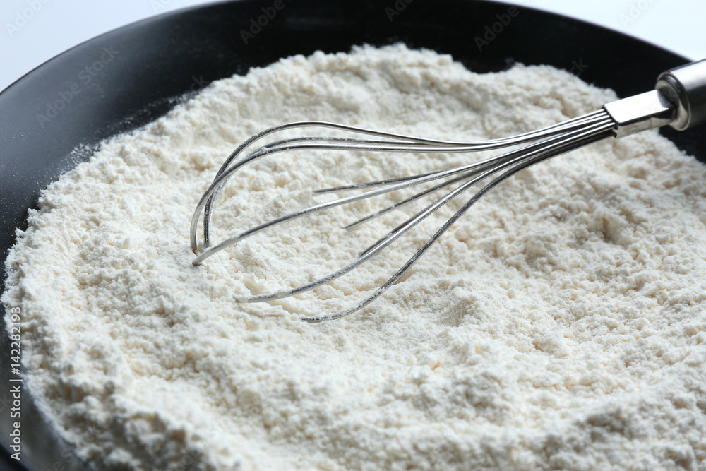 Whisk on flour, closeup StockFoto Adobe Stock