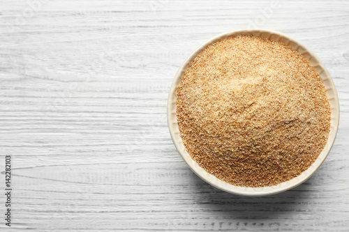 Small bowl of bread crumbs on wooden background