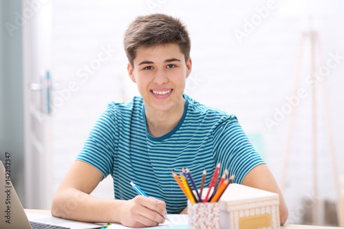 Teenager sitting at table a...