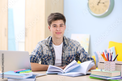 Teenager sitting at table a...