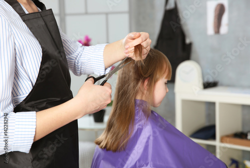 Cute little girl in hairdressing salon