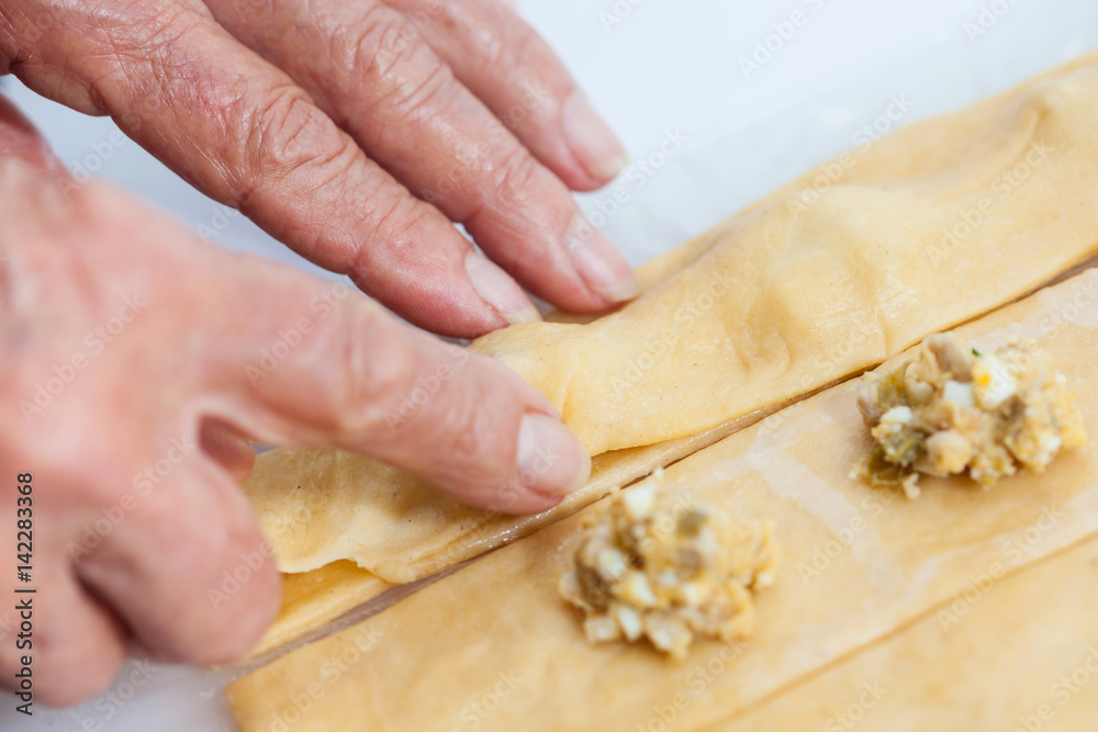 Ravioli Preparation : Placing the upper dough strip to seal the ravioli