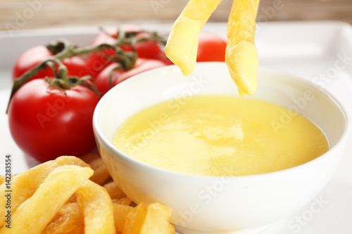 Delicious french fries with cheese sauce, closeup