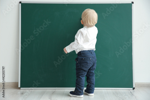 Cute little boy writing on ...