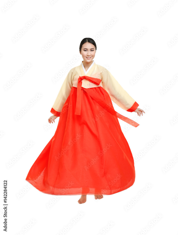 Beautiful young woman in Korean traditional costume dancing on white background Beautiful young woman in Korean traditional costume dancing on white background