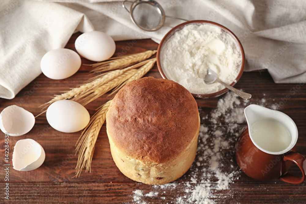 Delicious Easter cake and ingredients on wooden table Delicious Easter cake and ingredients on wooden table