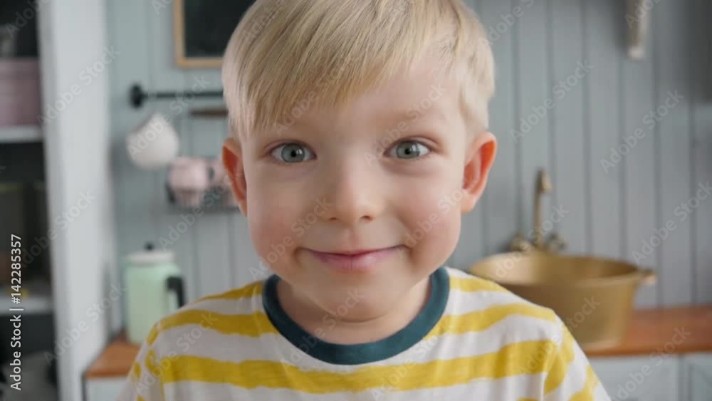 Portrait of happy little child boy over modern kitchen background at morning Portrait of happy little child boy over modern kitchen background at morning
