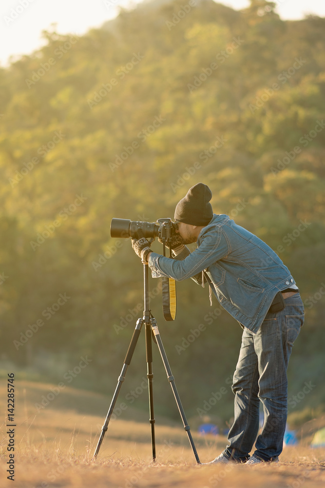 Handsome young professional photographer taking photos,