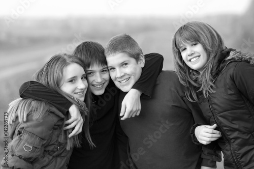 Teenage boys and girls hugging and having fun in the autumn nature in black and white