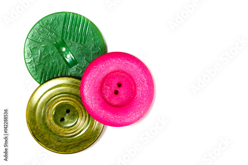 Three Plastic Vintage Buttons on pink, green, gold on white background with room for copy