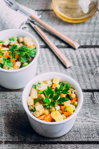 Healthy Vegetable salad with potato,carrot,pears and green onion in a white bowl on wooden table. Vegetarian food content.  photo