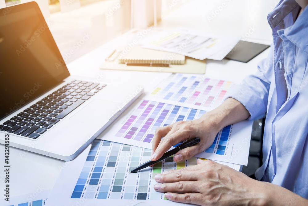 Fototapeta premium interior design or graphic designer renovation and technology concept - woman working with colour samples for selection.