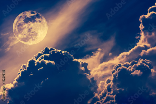 Nighttime sky with clouds and bright full moon with shiny. Vintage tone effect.