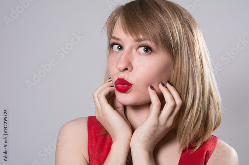 Close-up portrait of a young woman with red lips looking away