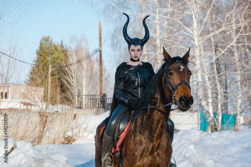 Billede på lærred Malefisenta. The beautiful girl with a horse.