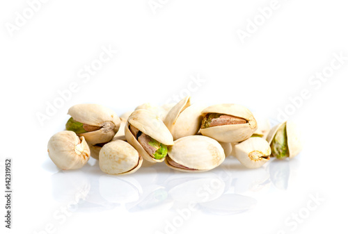 Roasted and salted pistachio nuts with shell with reflexion on white background