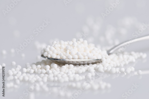 Granulated cassava (tapioca) in steel spoon isolated on white background