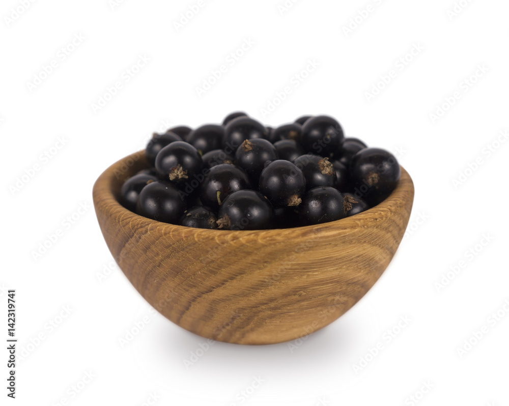 Black currant in a wooden bowl. Ripe and tasty currant isolated on white background. Black currant in a wooden bowl. Ripe and tasty currant isolated on white background.