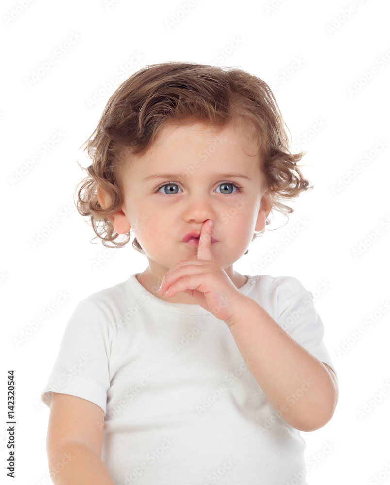 Cute baby has put forefinger to lips as sign of silence Cute baby has put forefinger to lips as sign of silence