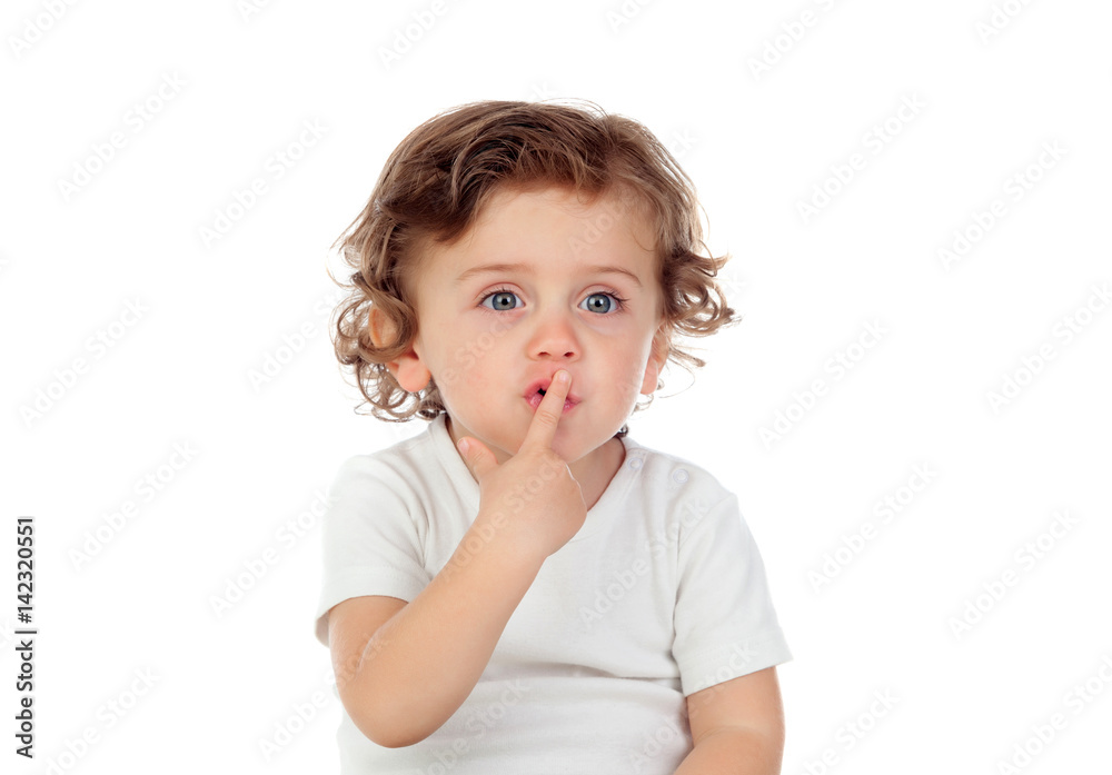Cute baby has put forefinger to lips as sign of silence Cute baby has put forefinger to lips as sign of silence