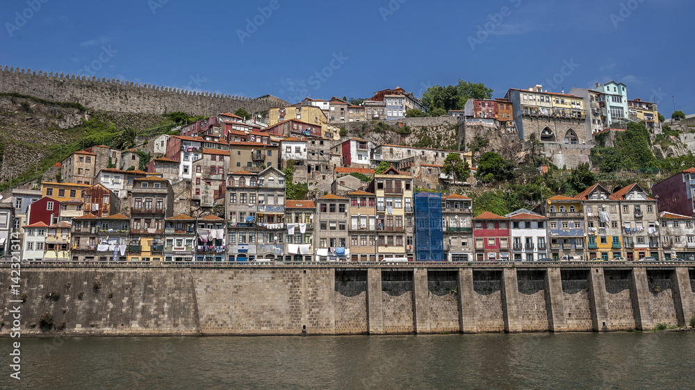 Portugal , Porto, the embankment of  Duero river , residential quarters of the old town , on the balconies drying clothes . The fortress wall .