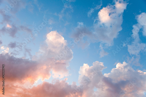 Beautiful sky background with colored clouds at sunset with sun setting down.