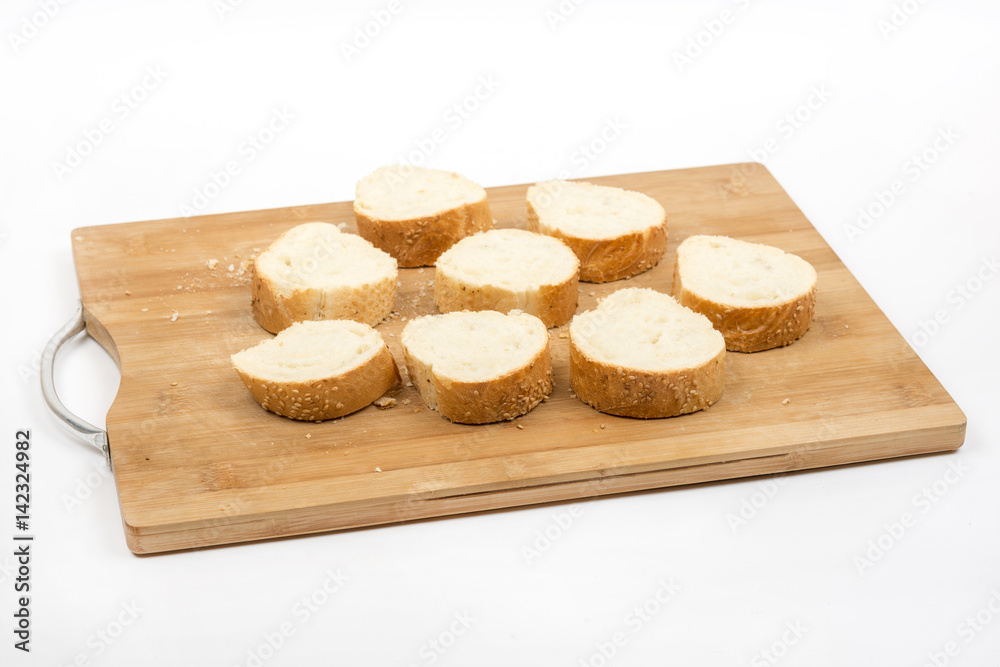 Sliced french bread isolated over white on the wooden board