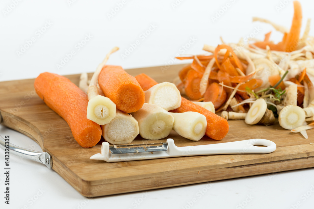 Peeled carrots and parsnips on the cutting wooden board Peeled carrots and parsnips on the cutting wooden board