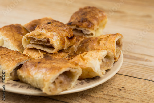 Slices of apple pie on the plate over wooden table