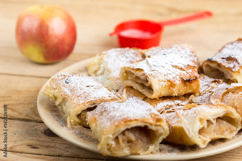 Apple pie sliced on the plate with powdered sugar Apple pie sliced on the plate with powdered sugar